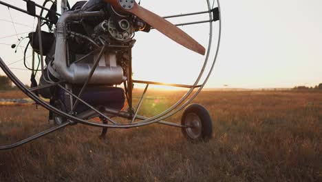 motor paraglider stands at the airport in the rays of sunset sunlight. the camera moves along the orbit. clouse-up