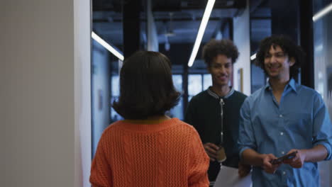 Happy-diverse-business-people-walking-and-talking-with-documents-at-office