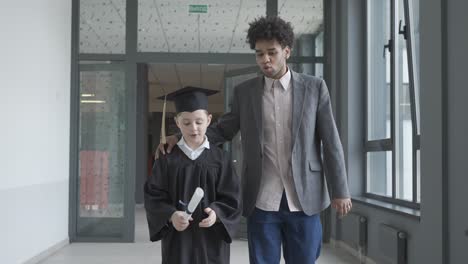 teacher touching his student's back. they walk.