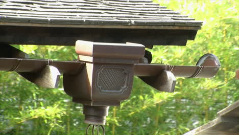 Copper-rain-gutter,-hinoki-shingles,-downspout-and-rain-chain-on-the-edge-of-a-traditional-Japanese-house