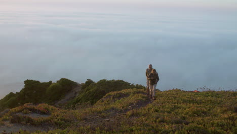 Happy-senior-couple-hugging-and-walking-on-mountain