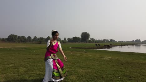 una bailarina de bharatnatyam que muestra una pose clásica de bharatnatyam en la naturaleza del lago vadatalav, pavagadh