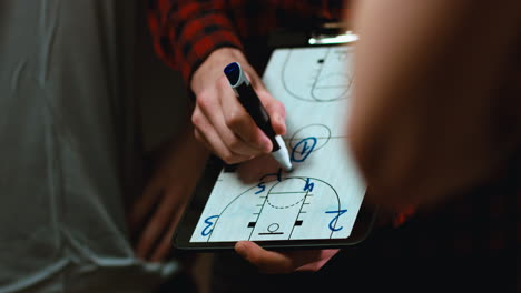 cu view of basketball coach using his tablet to explain combination to a team. 4k uhd