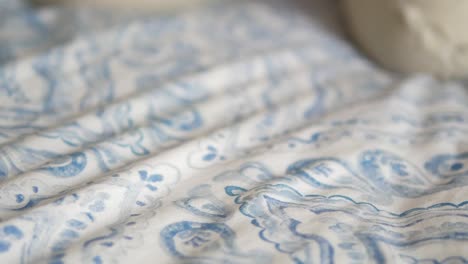 pink eyeglasses on a bed with a blue and white pattern