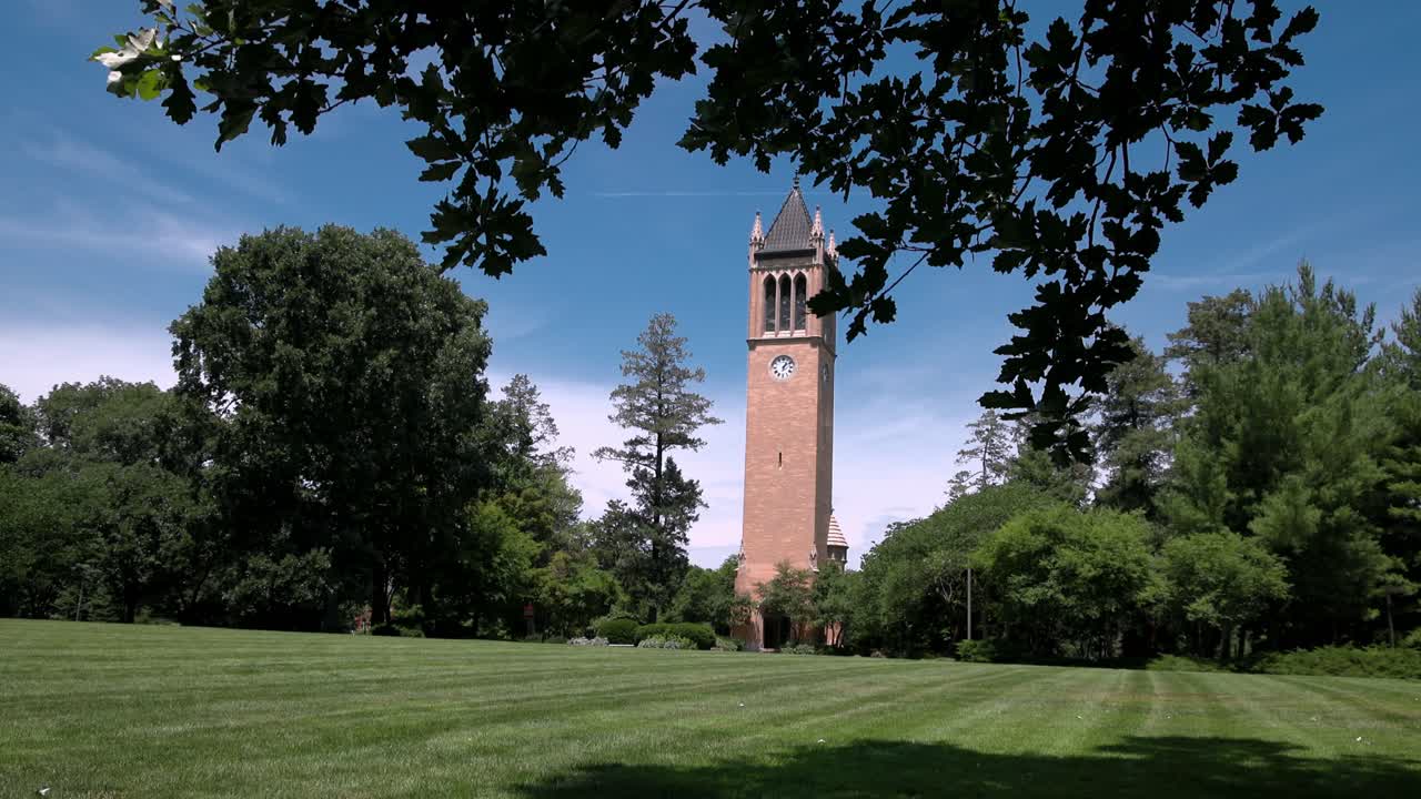 Iowa State University Campanile in Ames, Iowa with view through trees and lawn stable video wide