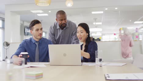 Group-of-diverse-business-people-using-laptop-and-talking-in-office,-slow-motion