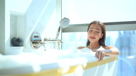 beautiful and sensual asian young woman bathing and relaxing in luxury bathtub of hotel room