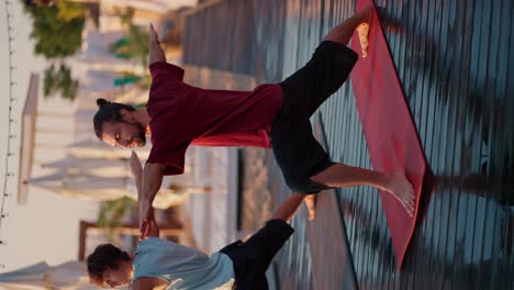 Zwei-Männer-Strecken-Ihre-Arme-Seitlich-Aus-Und-Machen-Yoga-Auf-Speziellen-Roten-Matten-Am-Strand.-Seelen--Und-Körperfrieden.-Harmonie,-Zen-Stil