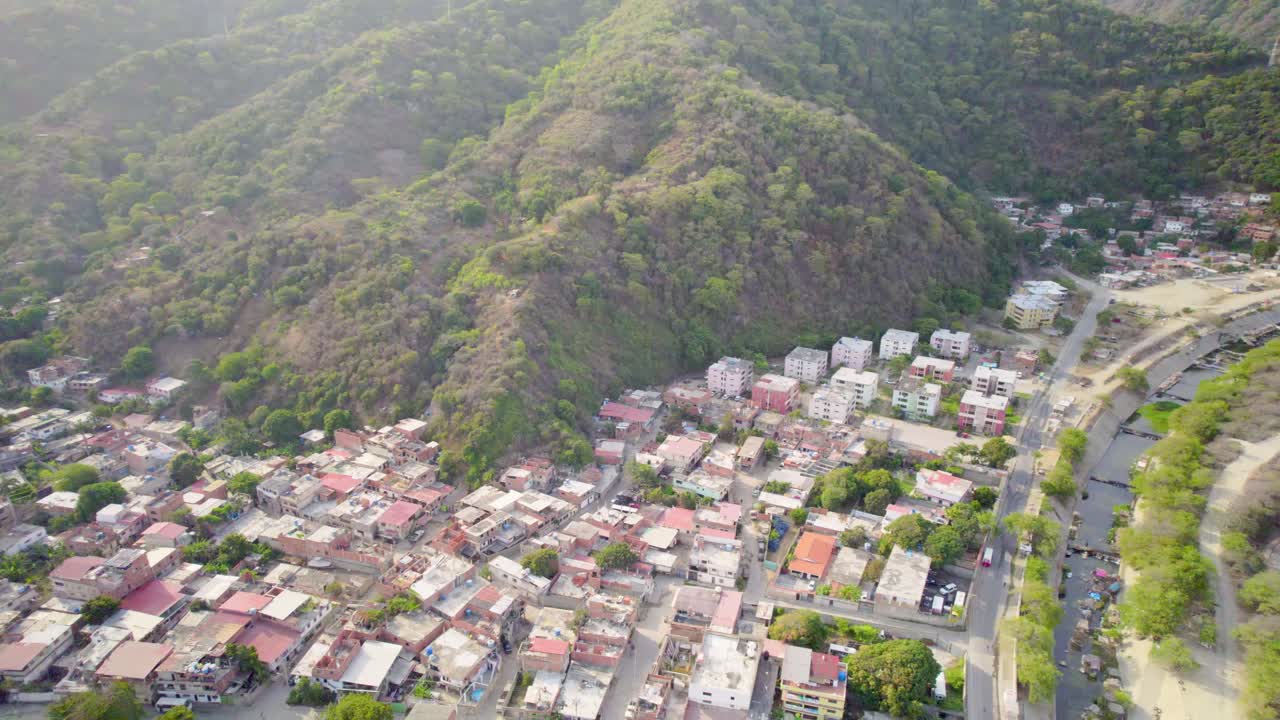 Pueblo camuri grande, with mountains and river, drone shot pan right, aerial view