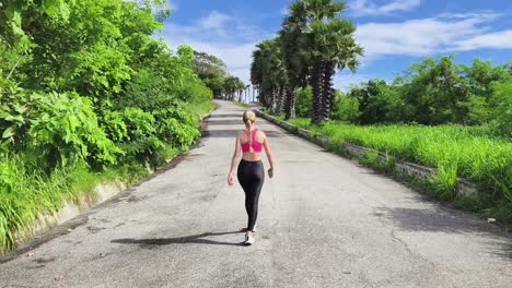 mujer caminando y tomando una selfie en un camino soleado