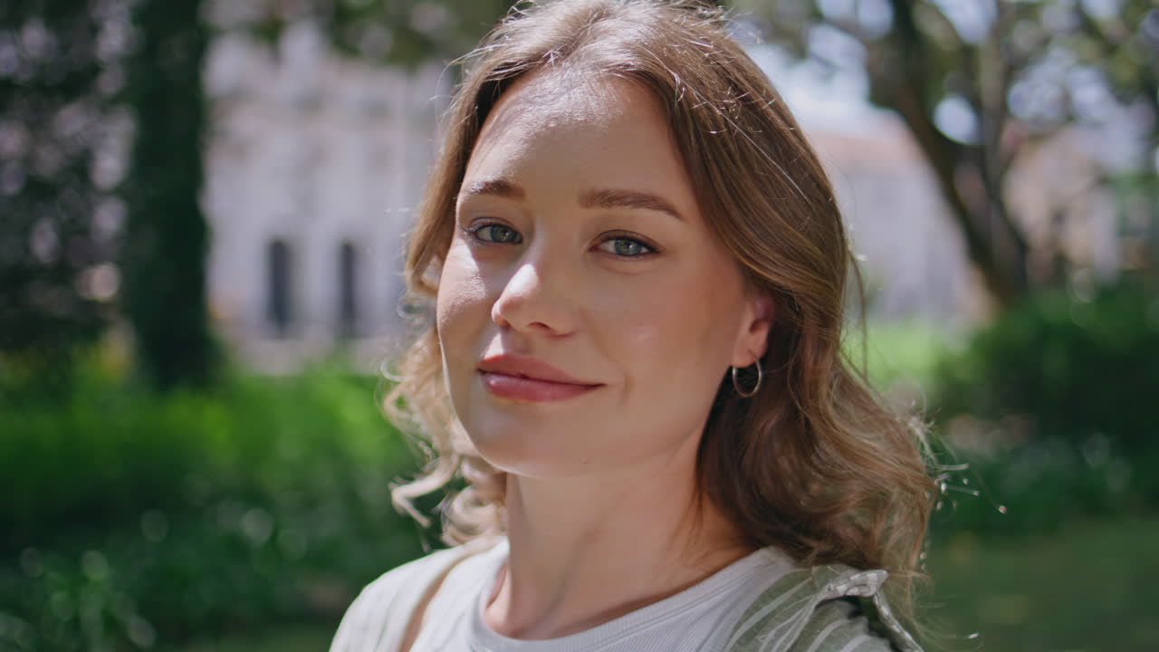 Attractive model posing park surrounded vivid greenery closeup. Portrait woman