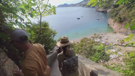 Beautiful-female-model-walking-down-the-stairs-in-Dubrovnik,-towards-the-beach