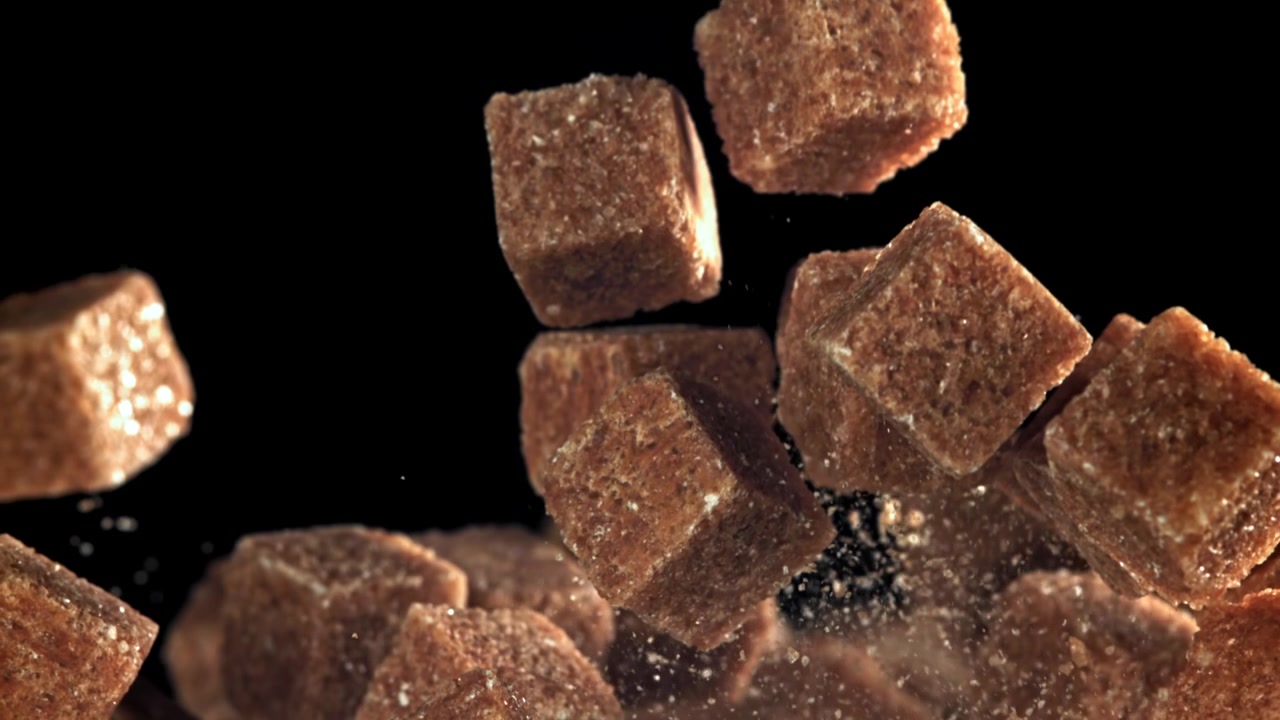 Brown Sugar Cubes Falling and Scattering in Slow Motion on Black Background