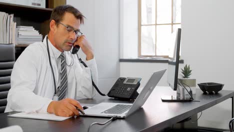 physician talking on landline at desk 4k