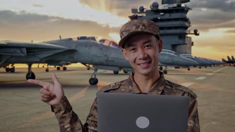 military officer with laptop on aircraft carrier deck