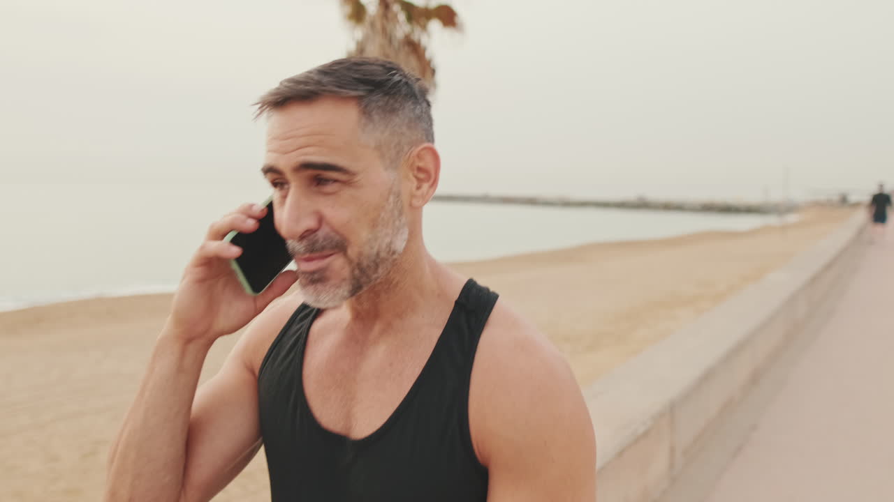 hombre hablando por teléfono en la playa