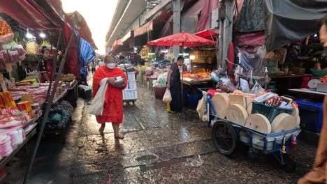 person navigating cart through busy wet market