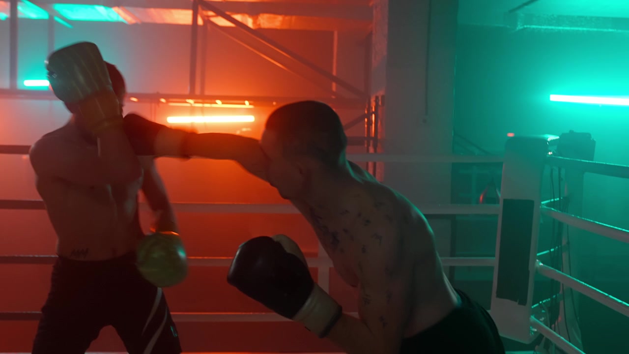 Dois Boxeadores Fazendo Sparring em um Ringue de Boxe Iluminado por Neon
