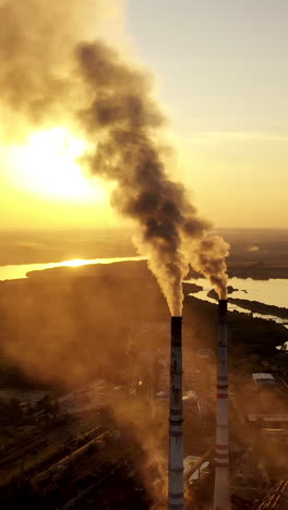 stream of smoke comes out from pipe. aerial view of industrial smoke stack of power plant. vertical video