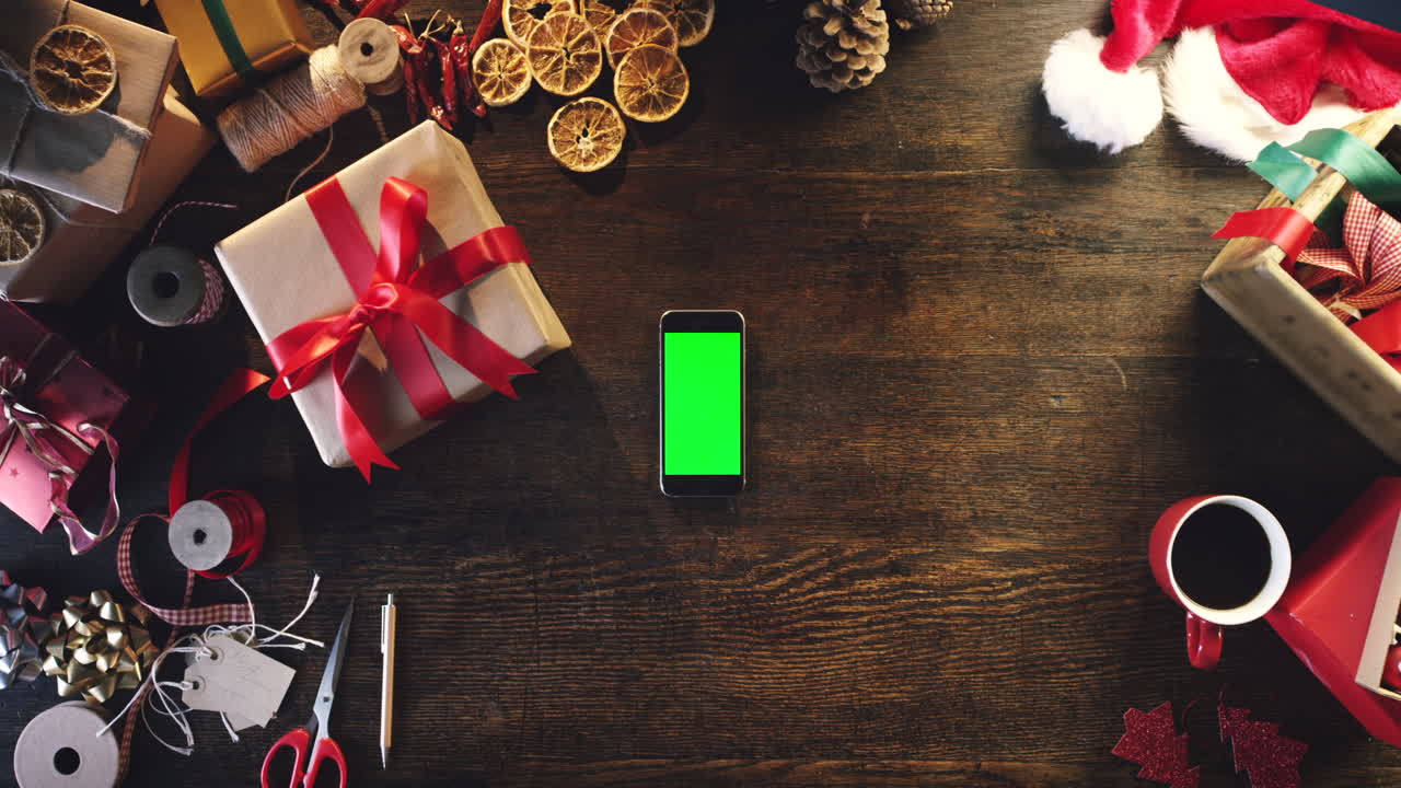 envoltura de regalos de navidad y maqueta de teléfono inteligente en mesa de madera