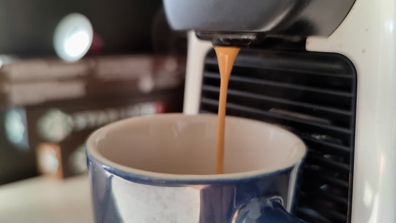 café cremoso en cámara lenta que se vierte en una taza azul