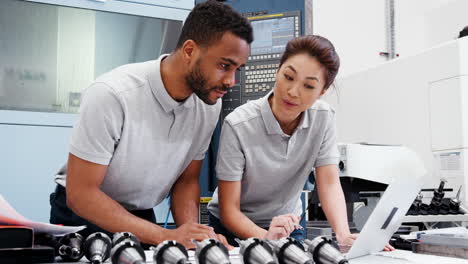 dos ingenieros discutiendo planes para el trabajo mientras miran la computadora portátil