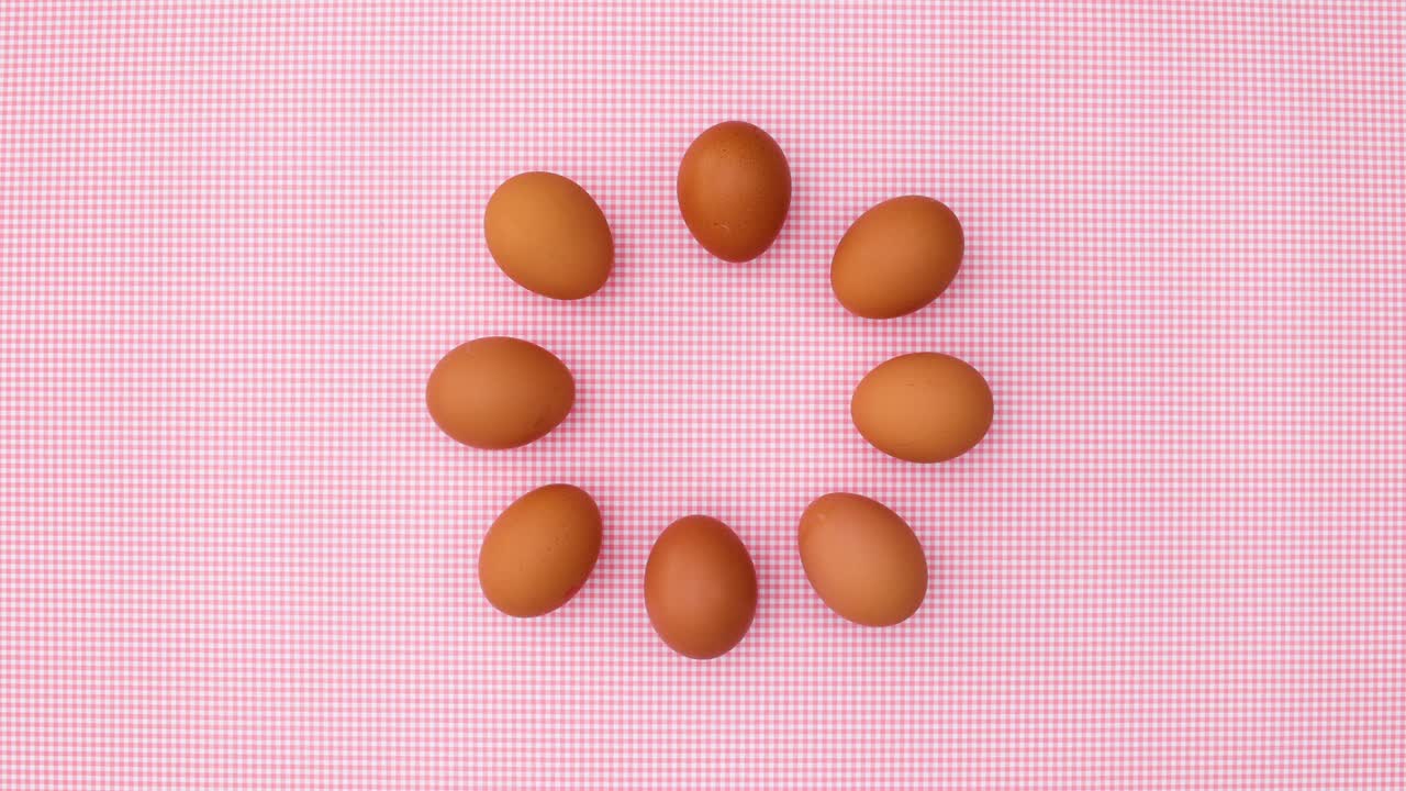 Creative dance of fresh eggs on pastel pink theme. Stop motion
