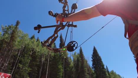 slow motion shot of an archer shooting an arrow in the mountains 3