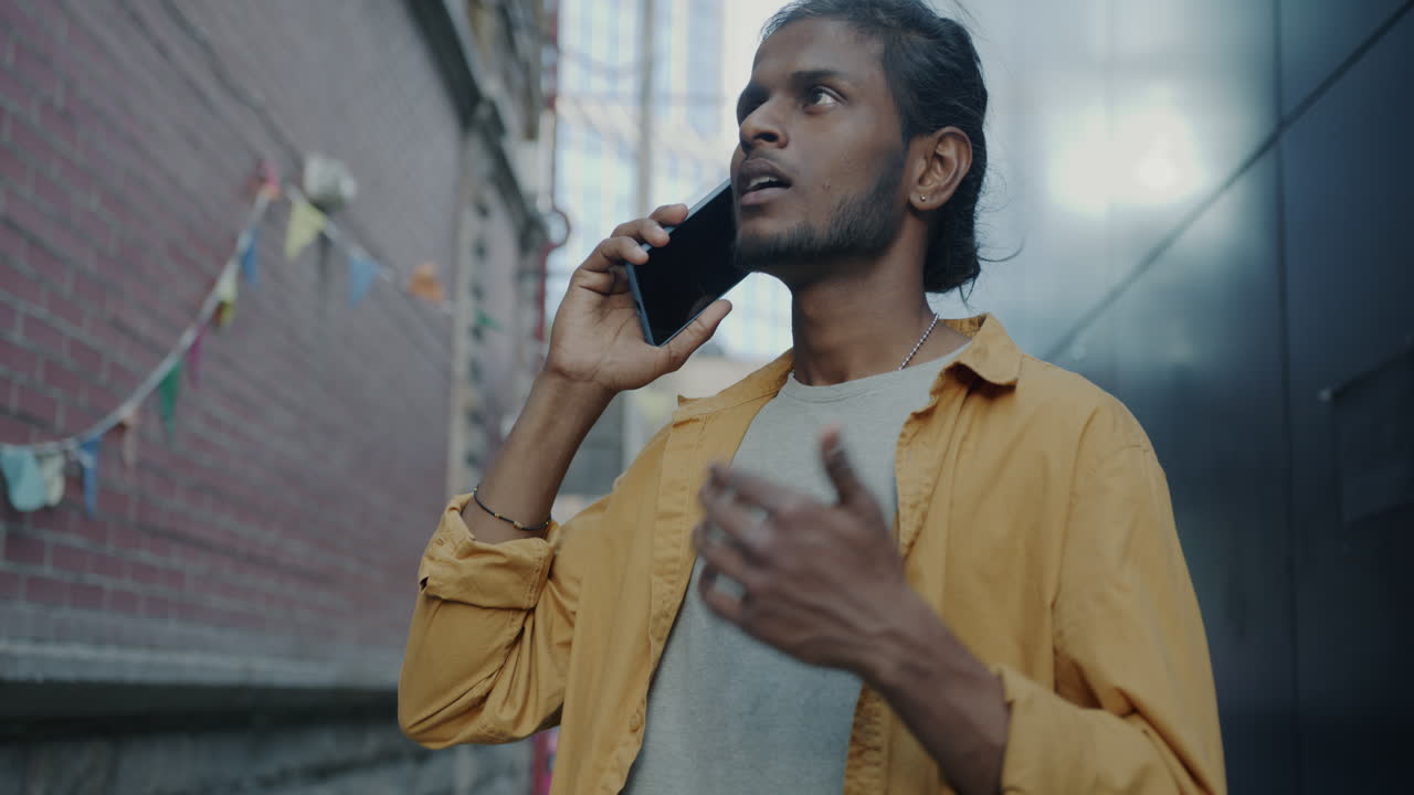 Young Man Talking on Phone in Urban Alley