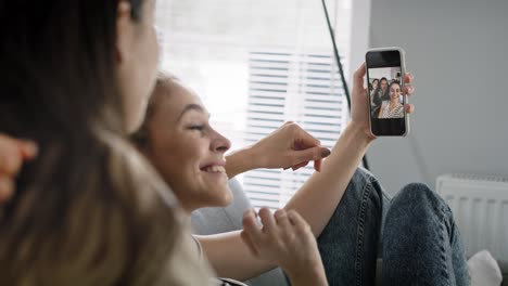 vídeo de mejores amigos sonriendo mientras miran sus selfies.