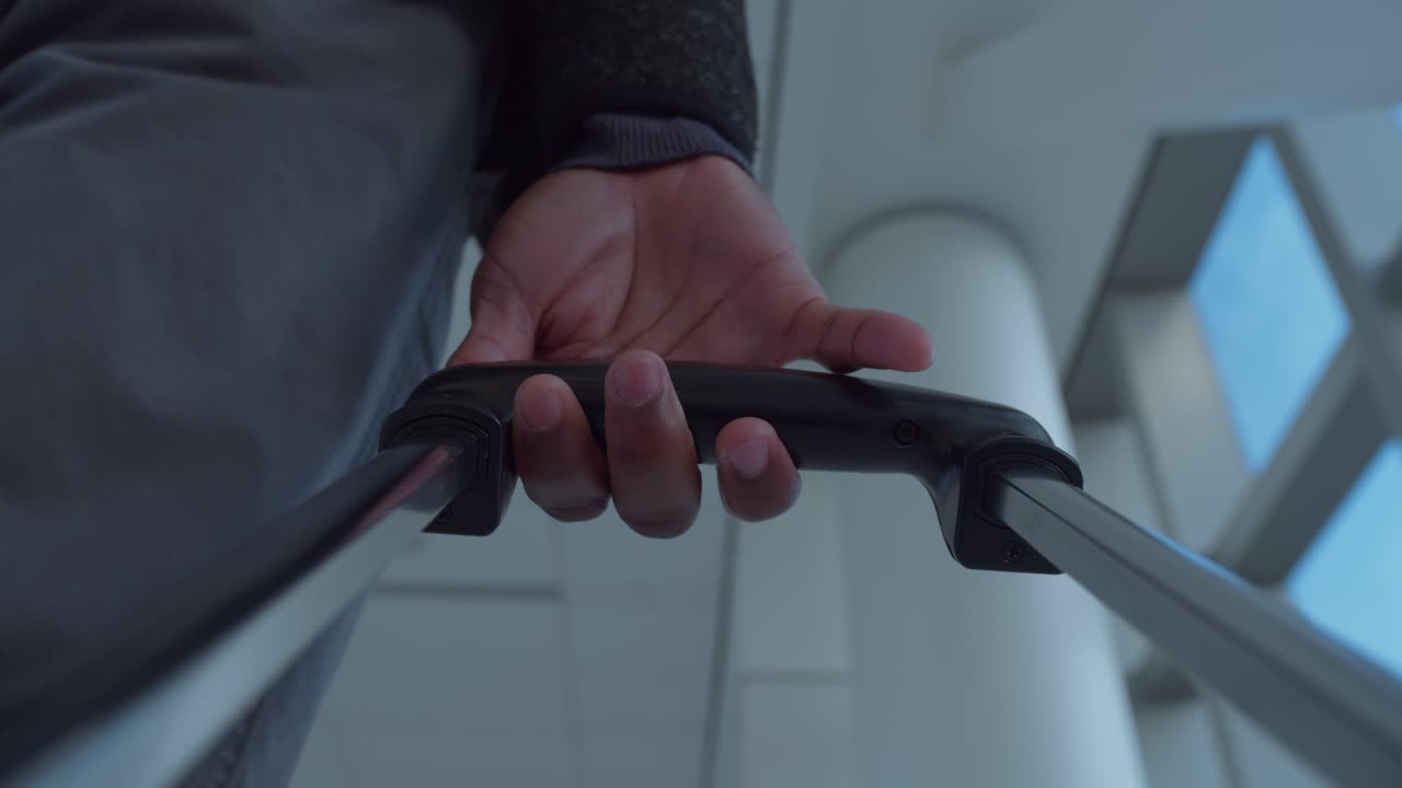 롤링 수을 끌고 현대 공항의 터미널에서 멈추는 남성 여행자