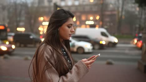 joven usando un teléfono inteligente en la ciudad por la noche