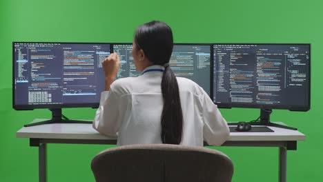 여러 컴퓨터 화면에서 작업하는 여성 프로그래머