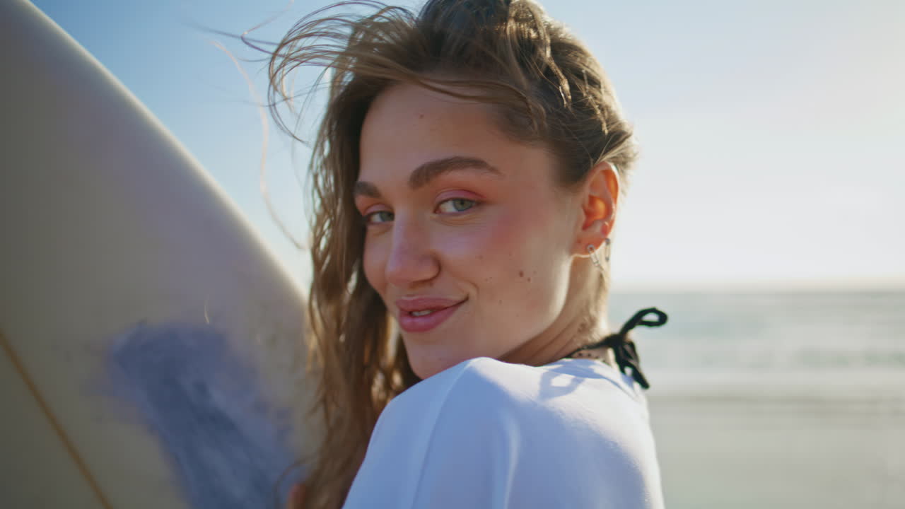 Flirting girl posing surfboard sunny beach closeup. Woman enjoying summer sport