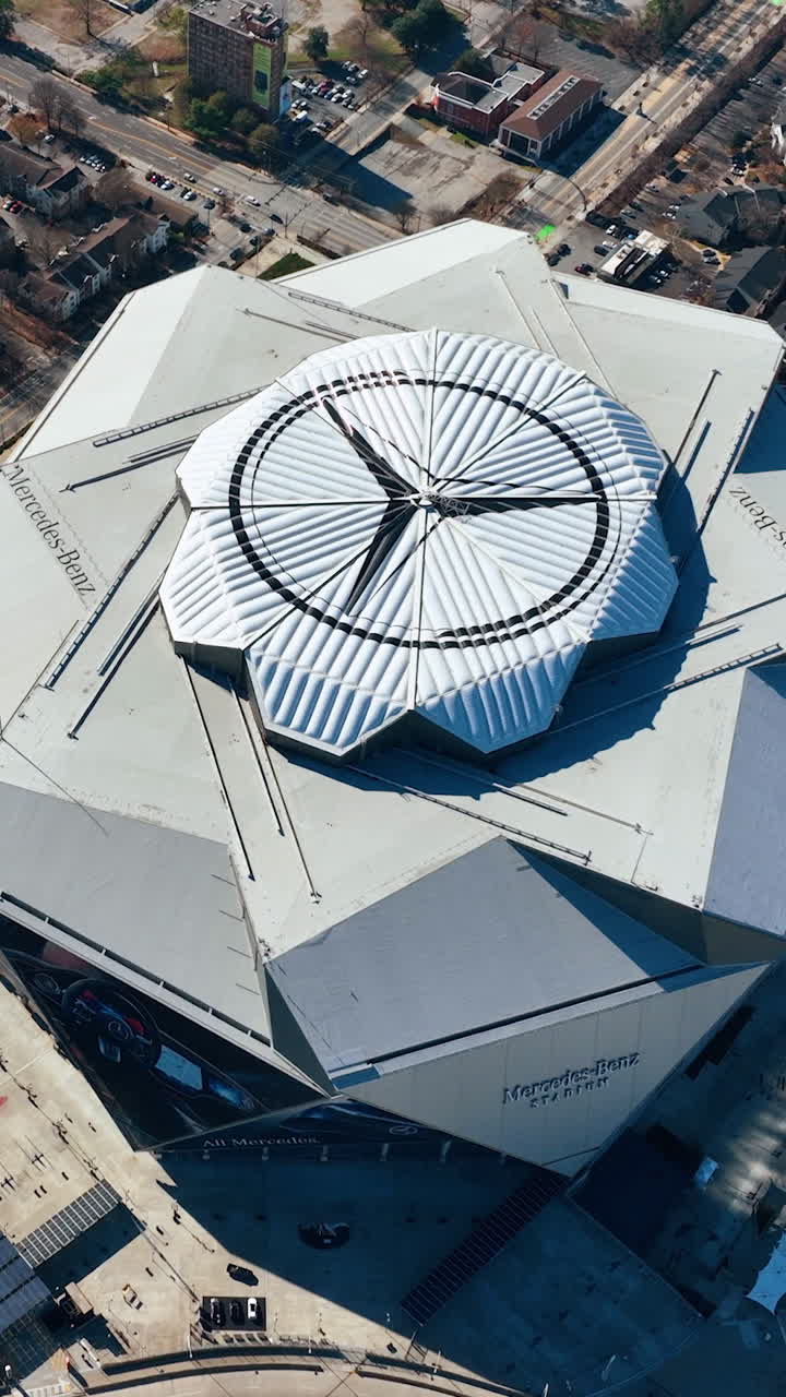 Atlanta, Georgia, USA - January 02, 2024: Aerial flight around the Mercedes Benz stadium. Rotate top view of roof sports building. Vertical video
