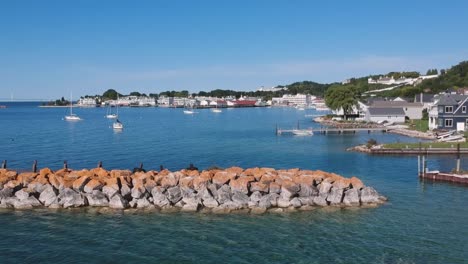 drone panning view of large rock seawall barrier near cape cod public marina