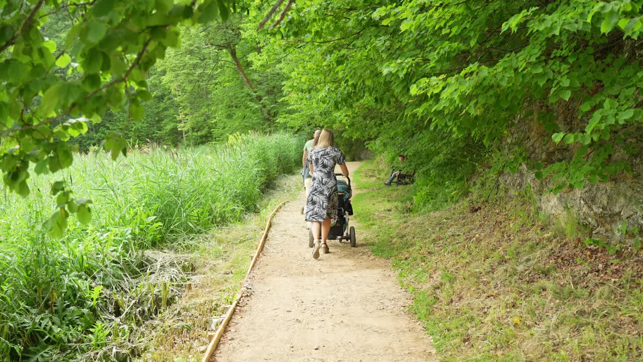 Mother Pushing Baby Cart Stroller: Blonde Woman's Loving Gesture, No Faces Shown