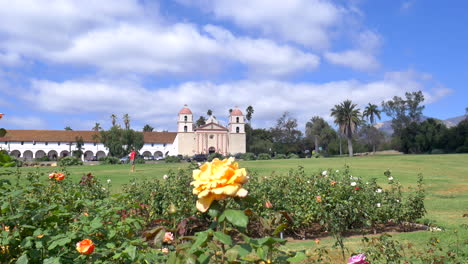 Das-Missionsgebäude-Von-Santa-Barbara-Unter-Blauem-Himmel-Mit-Blumen-Im-Vordergrund-Im-Rosengarten-In-Kalifornien