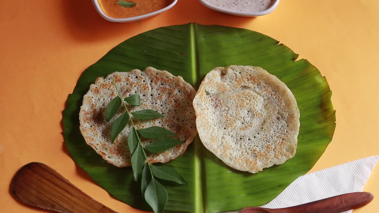 conjunto giratorio de comida del sur de la india dosa con curry y chutney sobre fondo amarillo