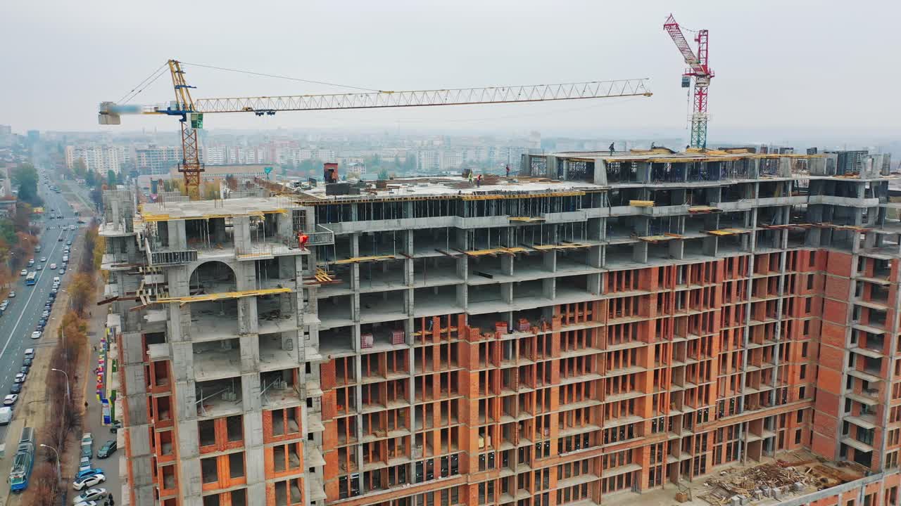 Construction site from height. Drone aerial view of new development with cityscape in background