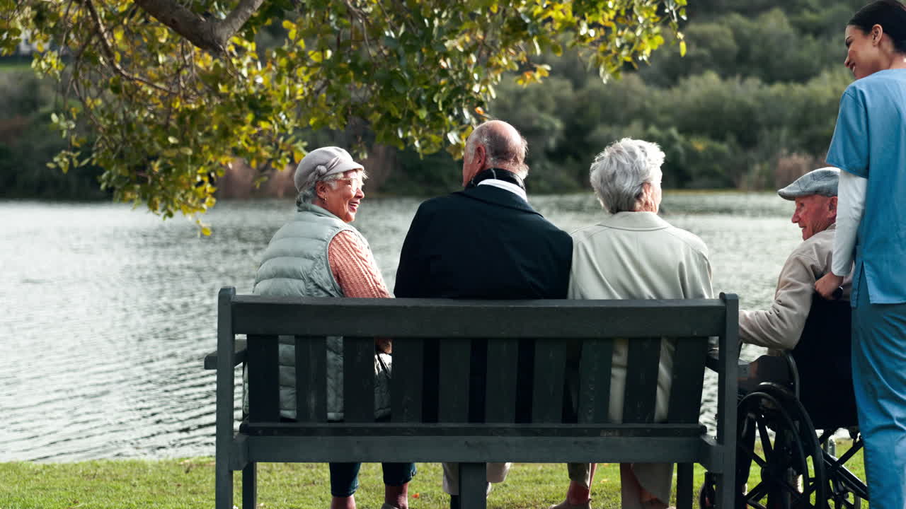 Senior citizens relaxing in a park by the lake