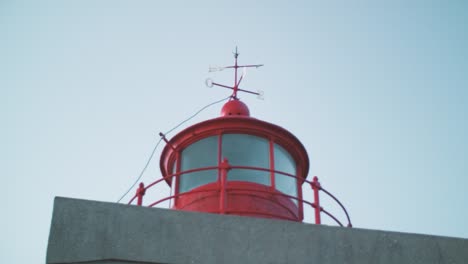 antiguo faro rojo y encantador &quot;farol&quot; con flechas para puntos cardinales, tarde de verano tardío, nazare en portugal