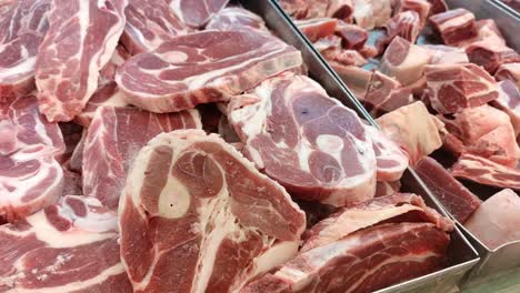 slices of frozen beef neatly arranged on a tray in a supermarket. ready for purchase, the meat is displayed under bright lighting, emphasizing its freshness and quality.
