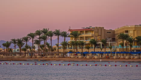 sunrise time-lapse in hurghada beach with palm trees, resorts, and majestic mountain silhouette at sunrise egypt, africa