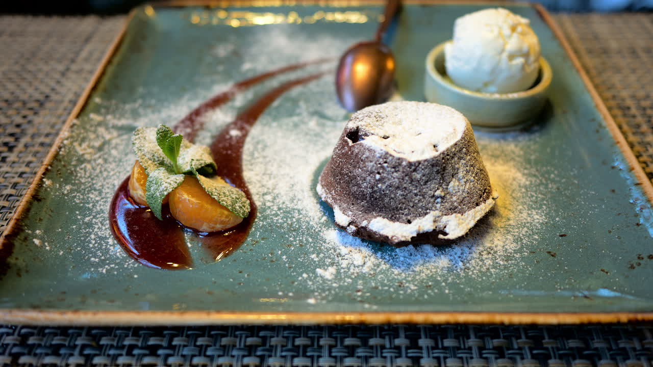 Chocolate lava cake with ice cream and orange decoration in a restaurant