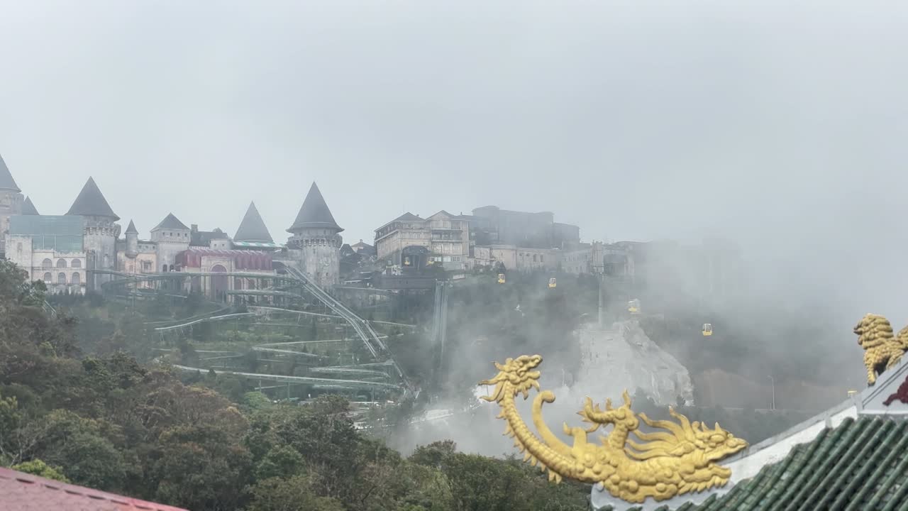 Sisli Da Nang'daki Sun World Ba Na Hills'in panoramik havadan çekimi; yemyeşil bir dağ fonunda ikonik kale yapıları ve sisle kaplı teleferikler büyüleyici bir sahne oluşturuyor.