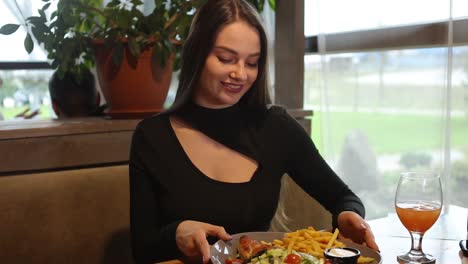 young attractive woman eating out in a restaurant food serving