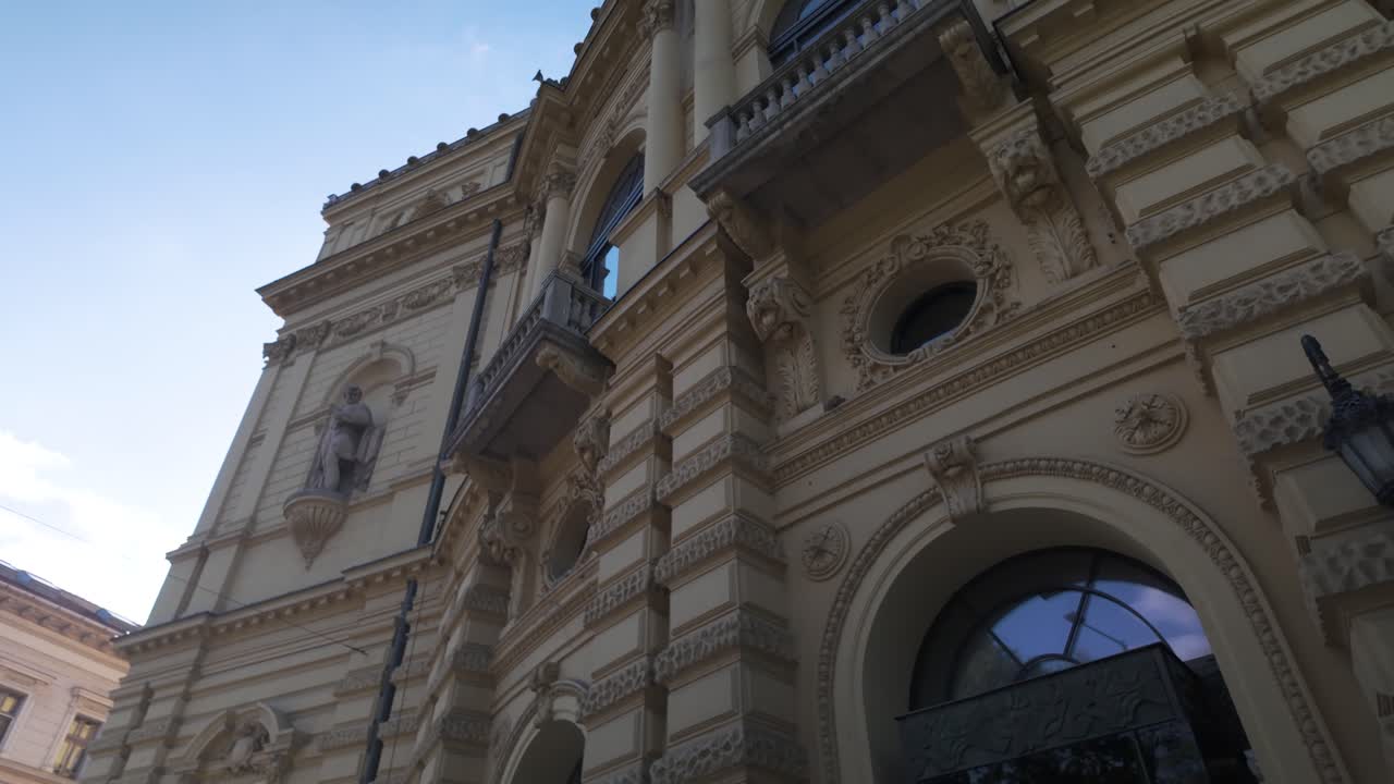Close-up view of the National Theatre of Szeged facade, glowing in golden light and showcasing its ornate architectural details