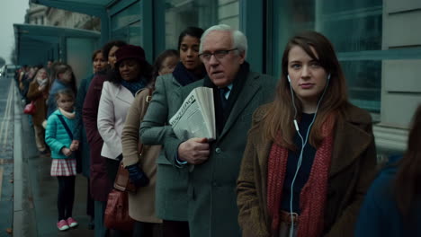 people queuing at an urban bus stop