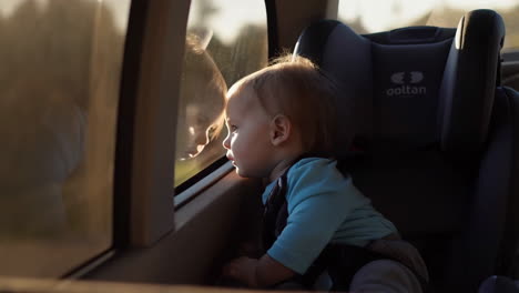 toddler looking out car window from car seat